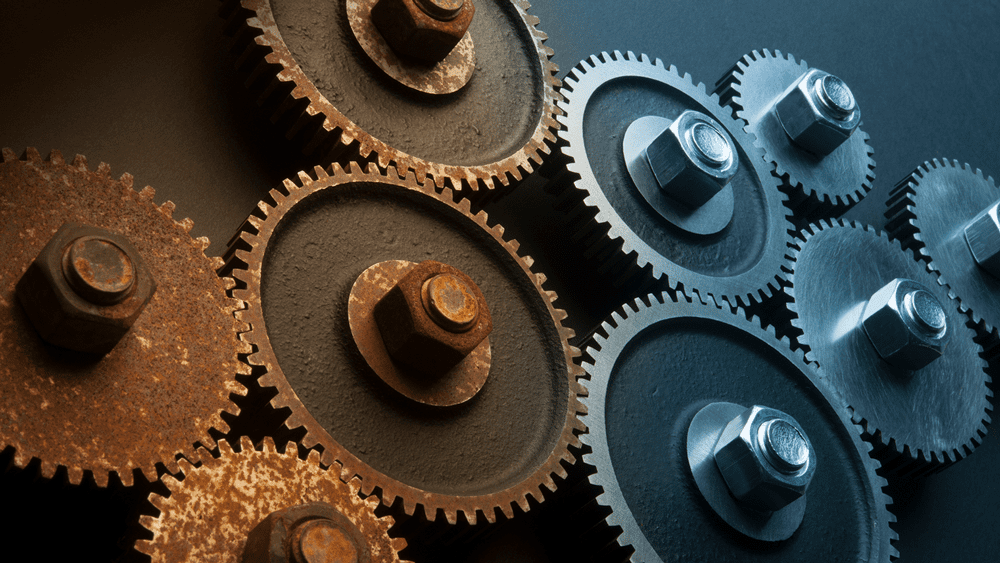 Detail of some rusty metal cog wheels, alongside clean ones